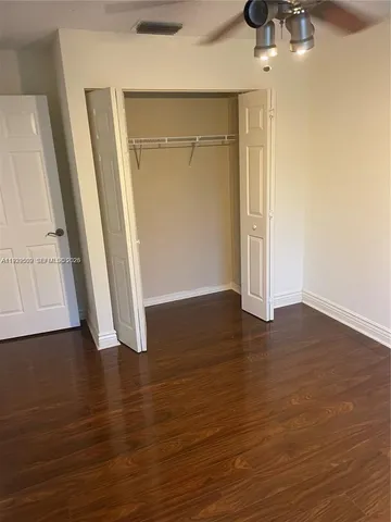 an empty room with wooden floor and closet