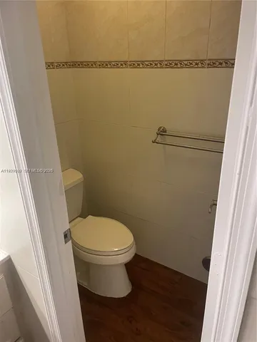 a white toilet sitting next to a shower