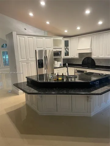 a kitchen with stainless steel appliances granite countertop a sink and a stove