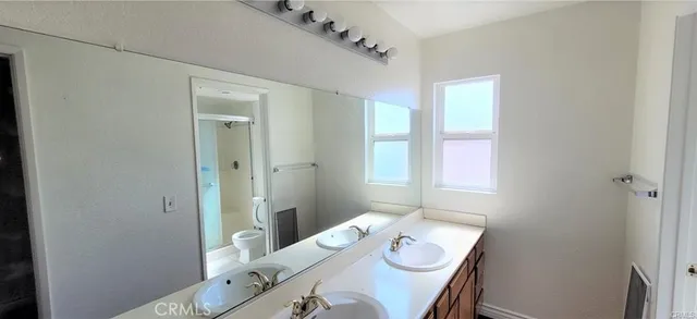 a bathroom with a granite countertop sink a toilet and shower