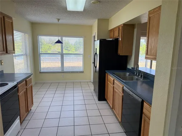 a kitchen with stainless steel appliances granite countertop a refrigerator a sink and a stove