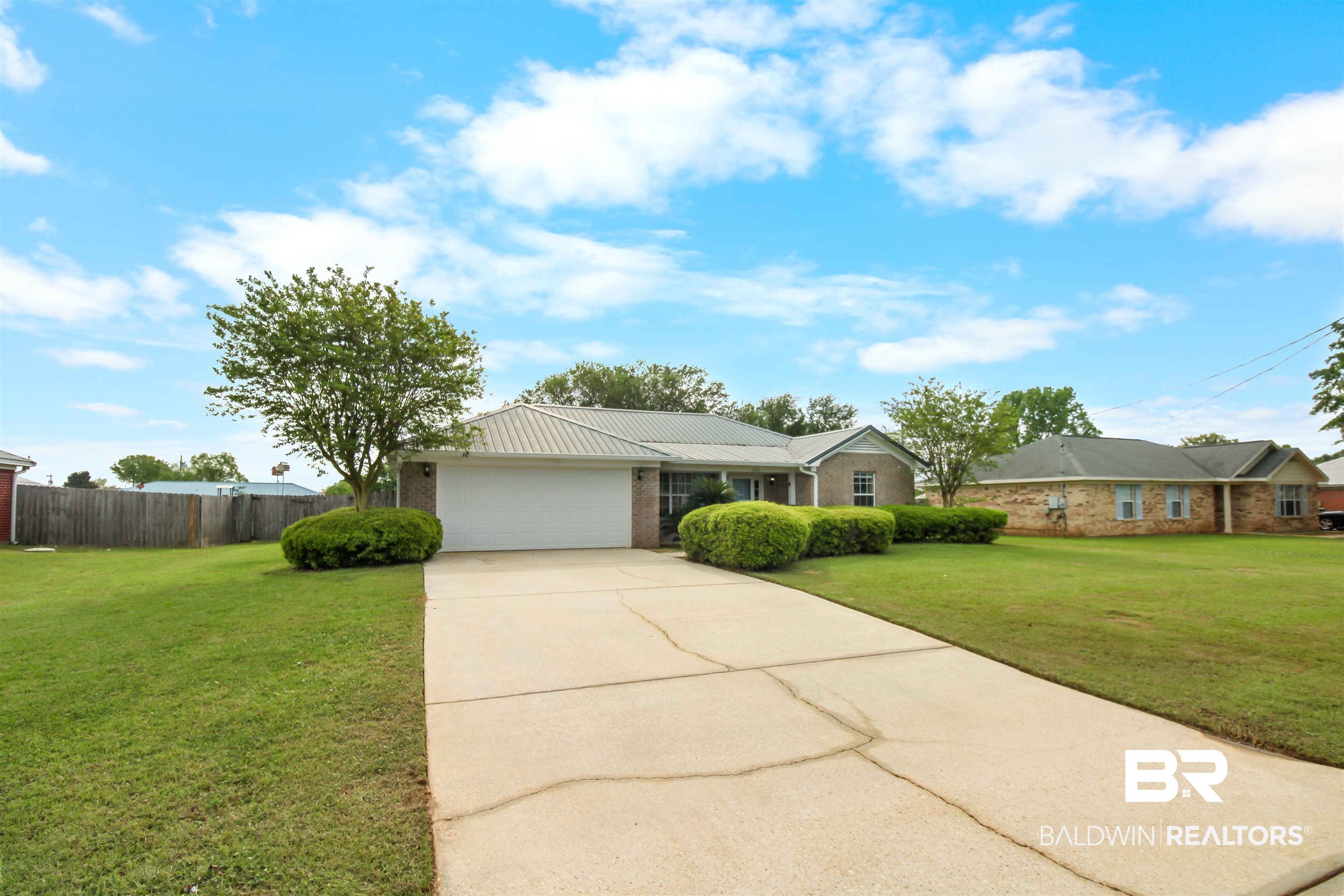 8940 Caitlin Street Foley, AL 36535 - Photo 22 of 27 Ranch-style home with brick siding, a garage, driveway, and a metal roof