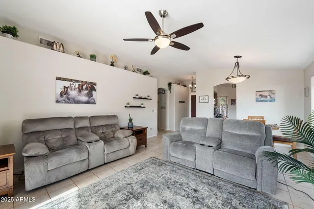 a living room with furniture and a ceiling fan