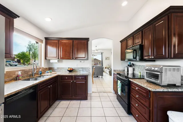 a large kitchen with stainless steel appliances granite countertop a sink stove and microwave