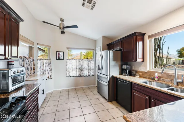 a kitchen with stainless steel appliances a sink stove refrigerator and cabinets