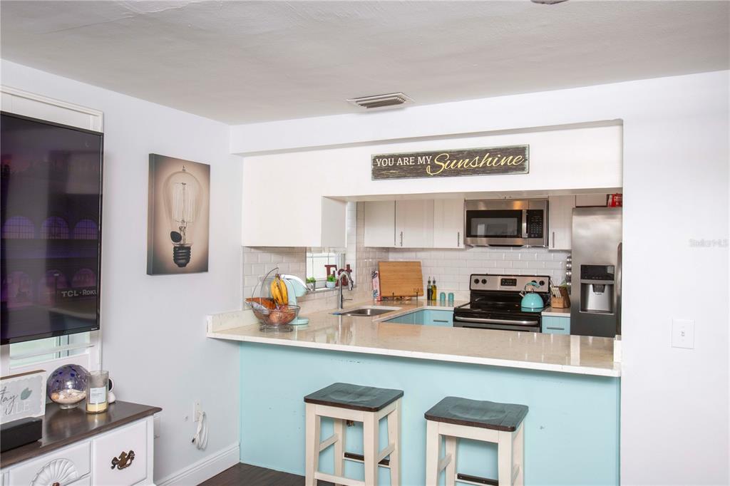 5240 School Road New Port Richey, FL 34653 - Photo 18 of 32 a kitchen with stainless steel appliances a sink a stove and white cabinets
