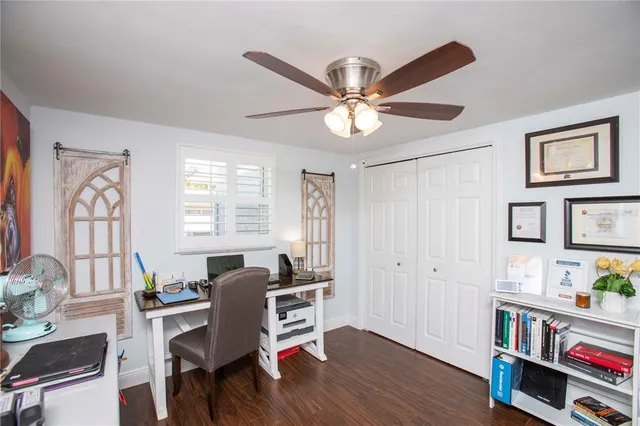 a view of a workspace with furniture and a window
