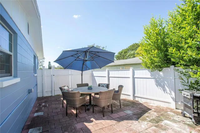 a view of a patio with table and chairs under an umbrella
