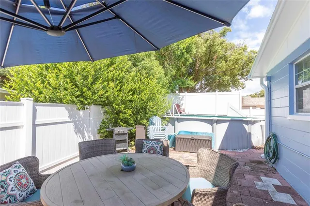a view of a patio with table and chairs under an umbrella