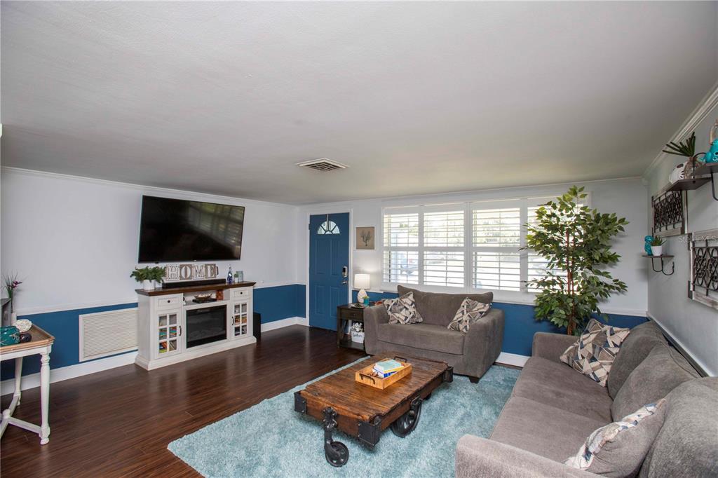 5240 School Road New Port Richey, FL 34653 - Photo 6 of 32 a living room with furniture flat screen tv and wooden floor