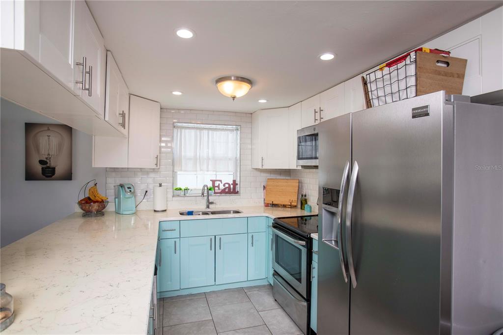 5240 School Road New Port Richey, FL 34653 - Photo 10 of 32 a kitchen with stainless steel appliances a refrigerator sink and microwave