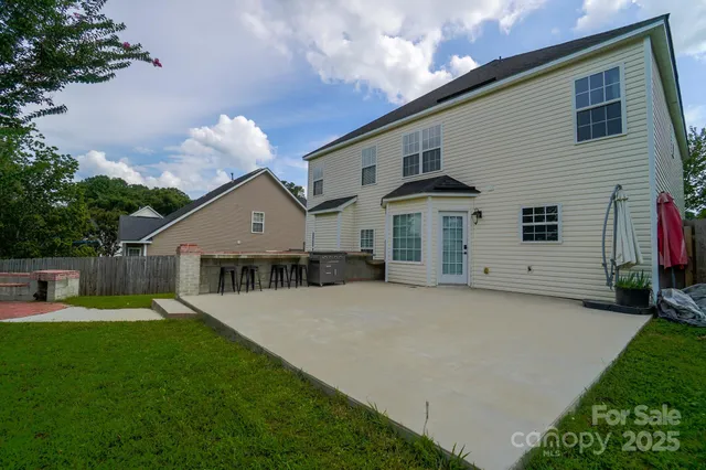 a view of a house with backyard and sitting area