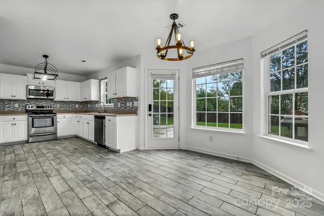 a large kitchen with stainless steel appliances granite countertop a stove and cabinets