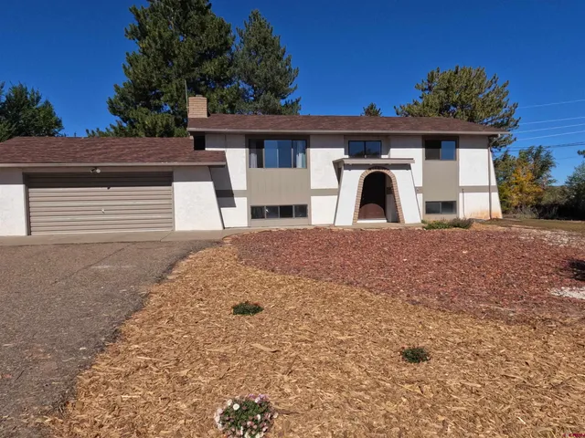 a front view of a house with a garden and garage
