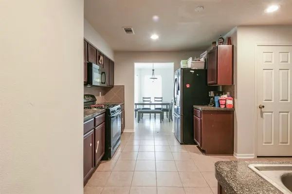 a kitchen with stainless steel appliances granite countertop a refrigerator and a stove