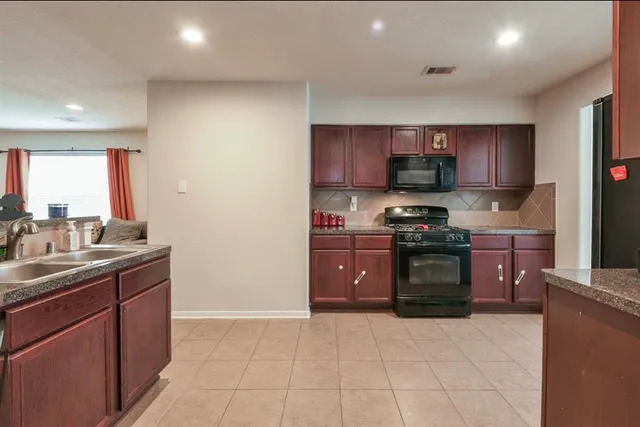 a kitchen with stainless steel appliances granite countertop a stove sink and cabinets
