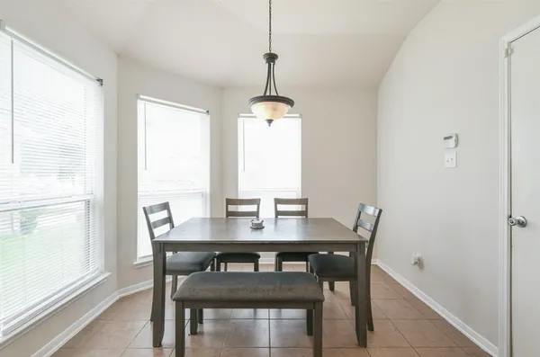 a view of a dining room with a table and chairs