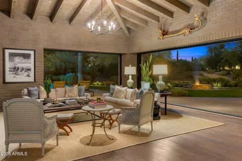 a living room with patio furniture and a floor to ceiling window