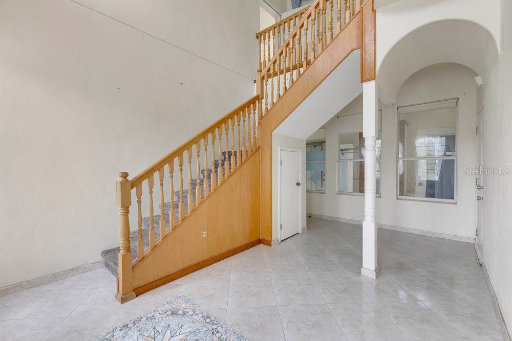 4110 Santa Barbara Road Kissimmee, FL 34746 - Photo 12 of 32 a view of staircase with railing and a chandelier