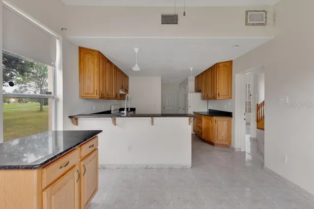 a large kitchen with stainless steel appliances a refrigerator sink and stove top oven