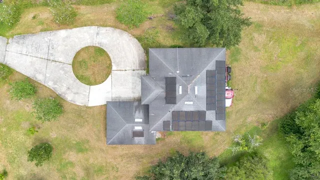 a aerial view of a house with swimming pool and trees