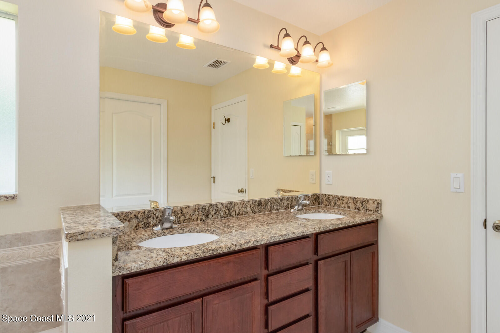 2524 Carmel Road Indialantic, FL 32903 - Photo 16 of 30 a bathroom with a granite countertop sink and a mirror