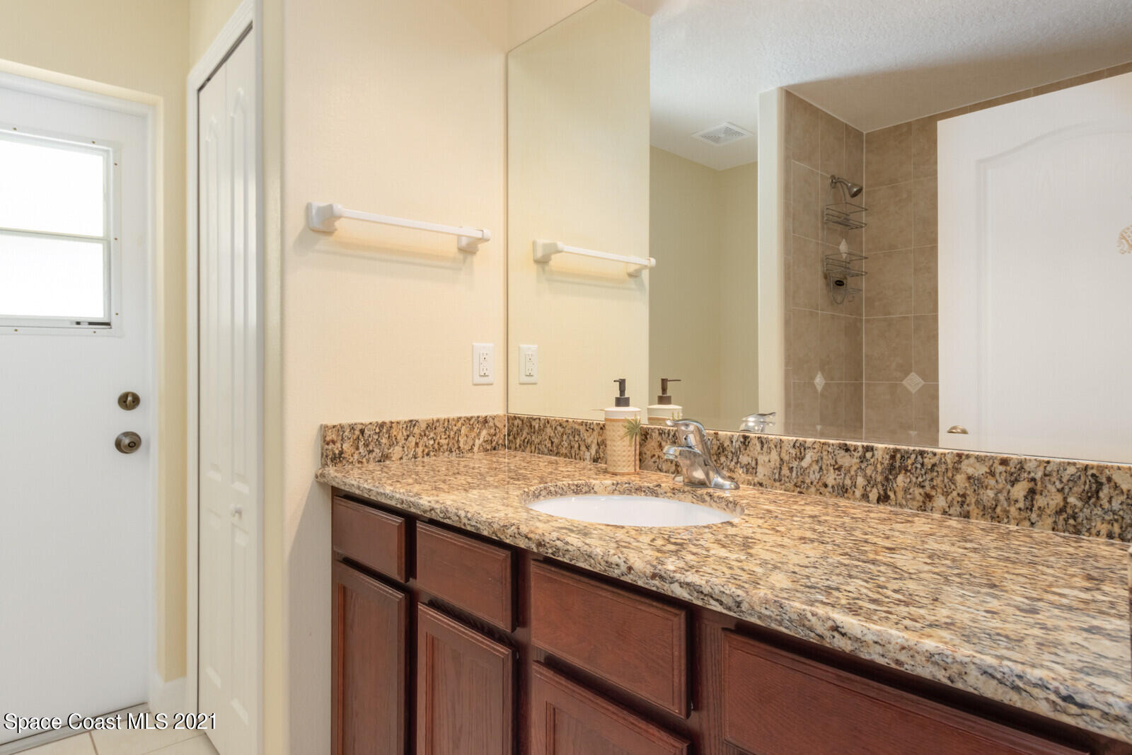 2524 Carmel Road Indialantic, FL 32903 - Photo 19 of 30 a bathroom with a granite countertop sink and a mirror