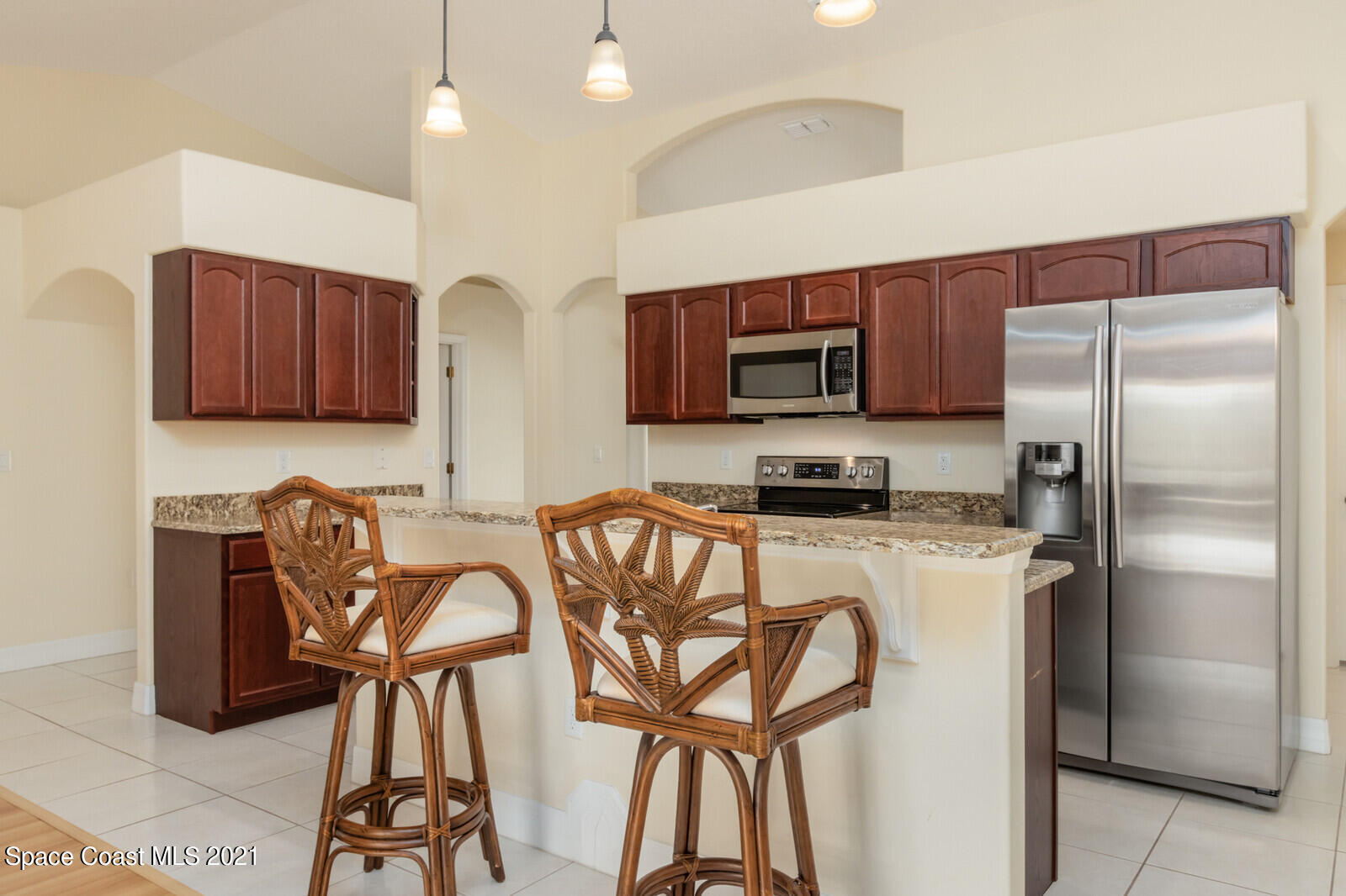 2524 Carmel Road Indialantic, FL 32903 - Photo 5 of 30 a kitchen with stainless steel appliances granite countertop a refrigerator a stove a sink and a table with chairs