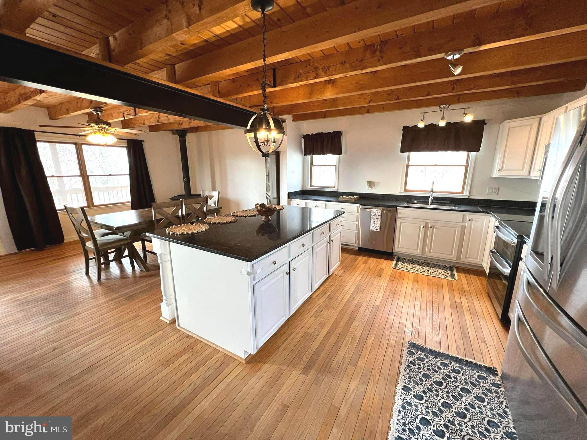 10680 Allens Fresh Road Charlotte Hall, MD 20622 - Photo 22 of 22 a kitchen with granite countertop a stove a sink and white cabinets with wooden floor
