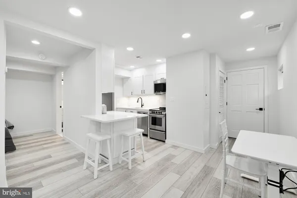a large white kitchen with a table and chairs in it
