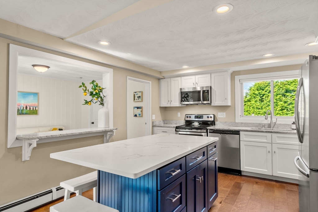 51 Griffin Road Framingham, MA 01701 - Photo 4 of 29 a kitchen with a stove a sink a microwave a center island and furniture