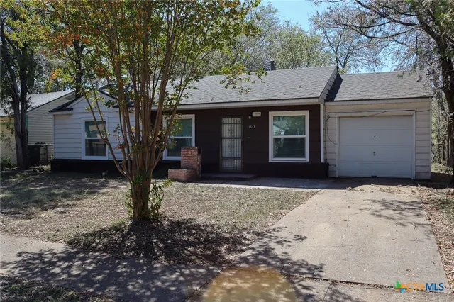 a view of a house with a tree in front of it