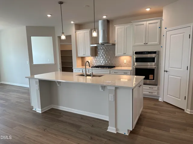 a kitchen with kitchen island a sink stainless steel appliances and cabinets