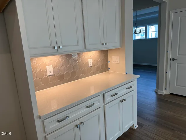 a view of a kitchen with wooden floor and cabinets