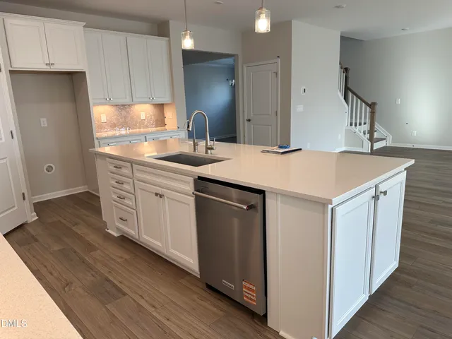 a kitchen with a sink cabinets and wooden floor