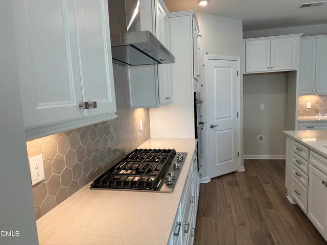 a kitchen with stainless steel appliances a stove a refrigerator and cabinets