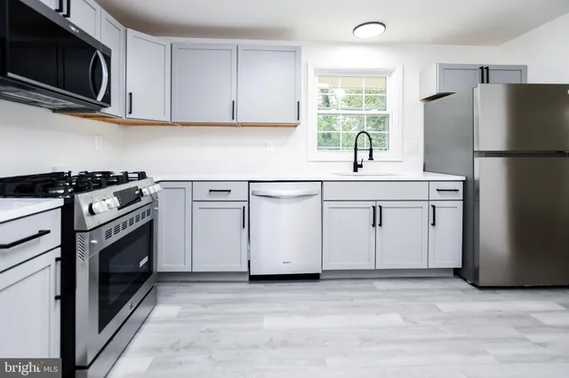 a kitchen with stainless steel appliances a stove microwave and refrigerator