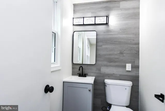 a bathroom with a toilet sink and mirror