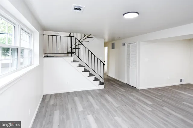 a view of a room with wooden floor and windows