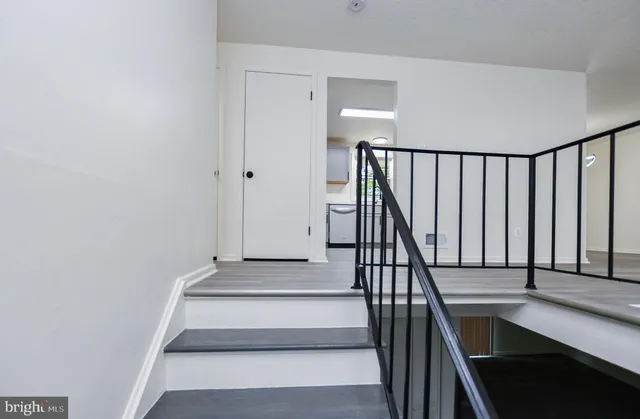 a view of staircase with white walls and railing