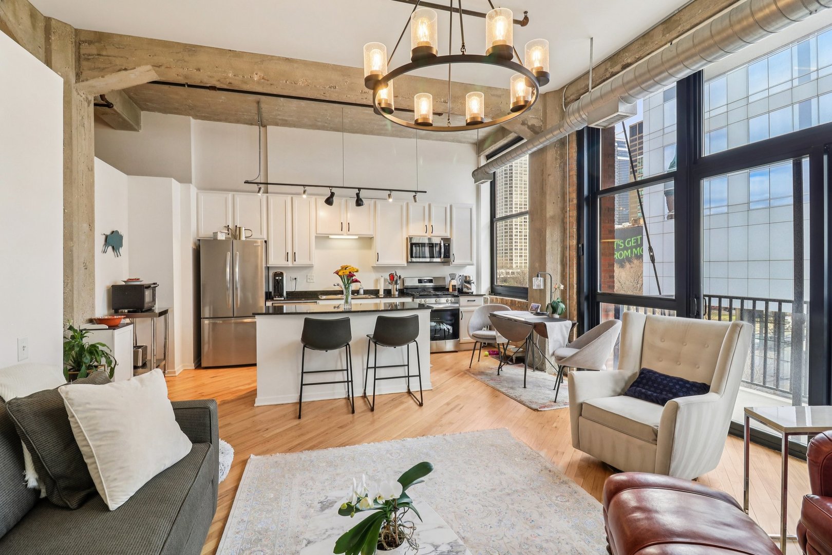 210 South Desplaines Street, Unit 304 Chicago, IL 60661 - Photo 4 of 19 a living room with furniture and a chandelier