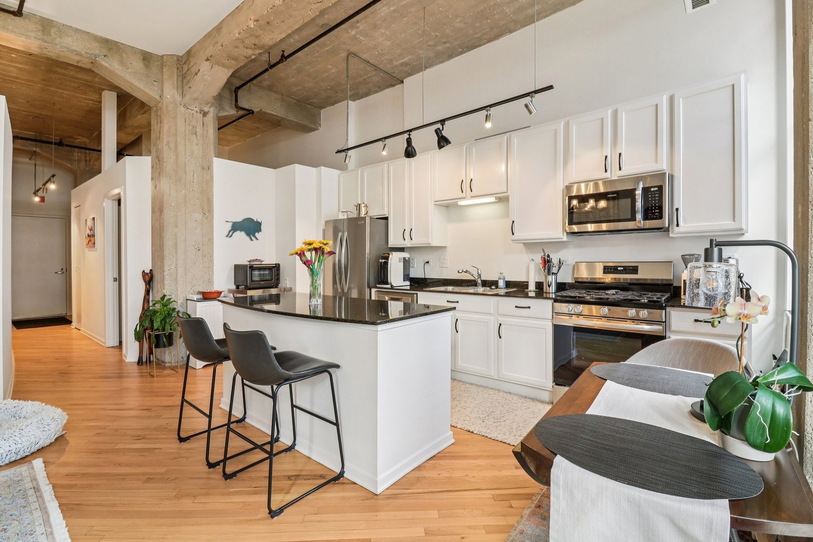 210 South Desplaines Street, Unit 304 Chicago, IL 60661 - Photo 5 of 19 a kitchen with stainless steel appliances kitchen island granite countertop a stove a sink and a refrigerator