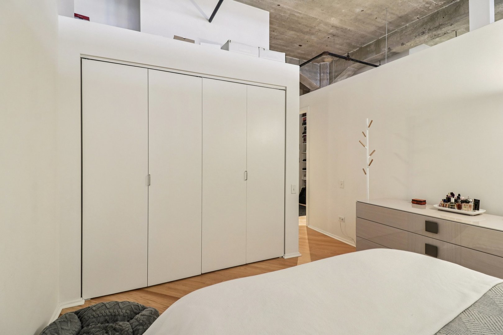 210 South Desplaines Street, Unit 304 Chicago, IL 60661 - Photo 7 of 19 a bedroom with a bed and a cabinets