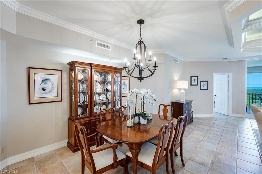 445 Dockside Drive, Unit B902 Naples, FL 34110 - Photo 10 of 29 a view of a dining room with furniture and chandelier