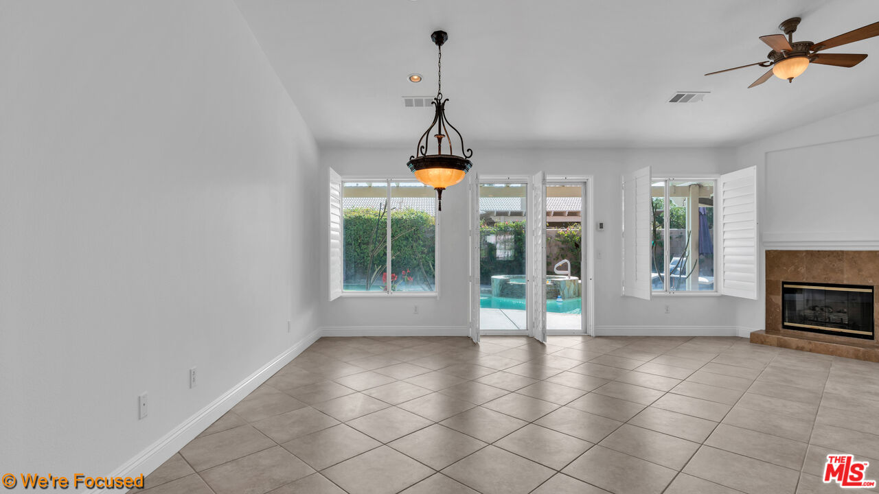 81129 La Reina Circle Indio, CA 92201 - Photo 15 of 46 a living room with furniture and a floor to ceiling window