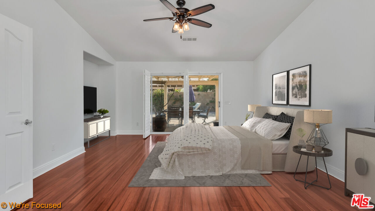 81129 La Reina Circle Indio, CA 92201 - Photo 20 of 46 a bedroom with a bed and wooden floor