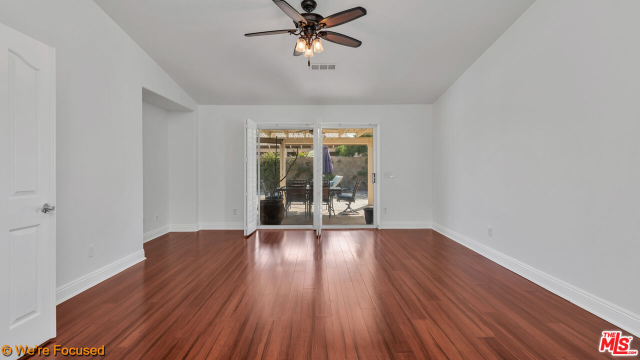 81129 La Reina Circle Indio, CA 92201 - Photo 21 of 46 a view of an empty room with wooden floor and a window