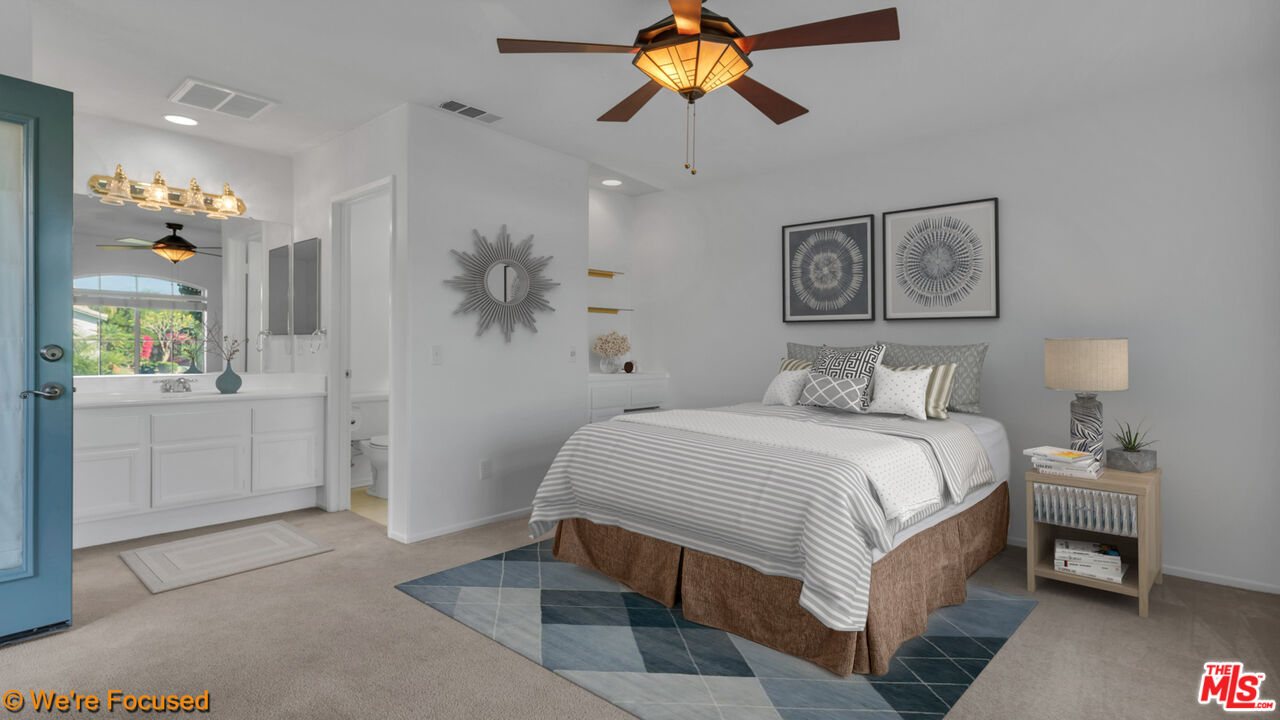 81129 La Reina Circle Indio, CA 92201 - Photo 32 of 46 a bedroom with a bed and a chandelier