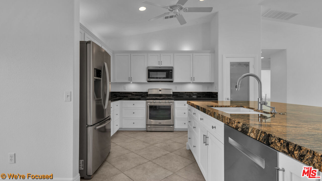 81129 La Reina Circle Indio, CA 92201 - Photo 8 of 46 a kitchen with granite countertop a refrigerator stove and sink