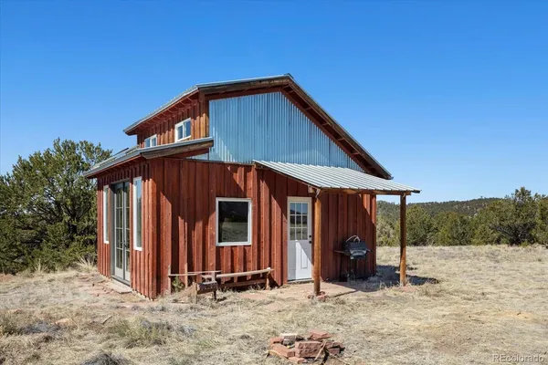 a view of a house with backyard and trees